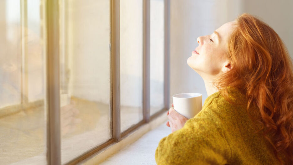 Eine junge Frau genießt den Sonnenschein. Unser Körper bildet Vitamin D in erster Linie mithilfe von Sonnenlicht. 